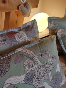 Les FinsChambres d'hôtes Au Doubs Murmure的一张床上的毯子,上面有孔雀的设计