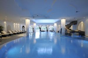 希明格古特伊辛酒店的酒店大堂的游泳池,配有白色椅子