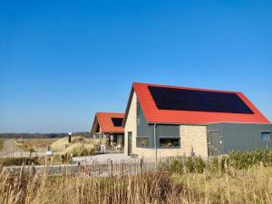 比伦Bed & Breakfast Slaperduin的屋顶上设有太阳能电池板的房子
