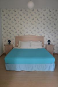 波罗斯Valente Perlia Rooms的卧室配有蓝色的床,墙上有鸟儿