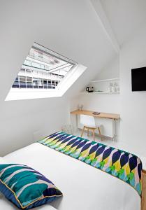 布鲁塞尔幸福旅馆的白色卧室配有一张带天窗的床