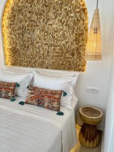 皮尔戈斯Thealos Santorini ( close to square)的一间卧室配有一张带两个枕头和一张桌子的床。