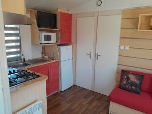 加的斯La Muela的一间小厨房,配有红色橱柜和白色冰箱