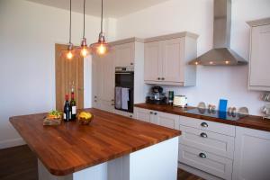 CreggansCreggans Cottage的厨房配有白色橱柜和木制台面