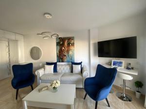 内尔哈Acapulco playa Nerja 407 planta superior的客厅配有白色沙发和蓝色椅子