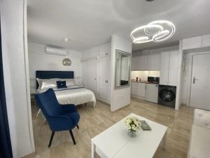 内尔哈Acapulco playa Nerja 407 planta superior的一间卧室配有一张床、一张蓝色的椅子和一张桌子