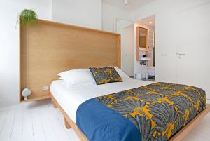 布鲁塞尔幸福旅馆的一间卧室配有一张大床和木制床头板