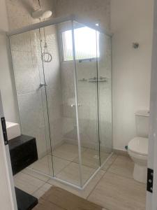 佩德拉贝拉VILLAGE Host Hotel的一间带卫生间的浴室内的玻璃淋浴间