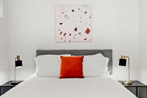 旧金山Kasa The Addison San Francisco的卧室配有白色的床和红色枕头