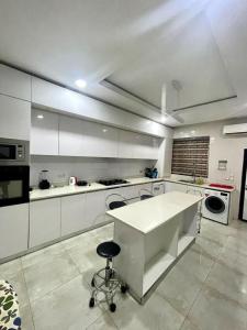 拉各斯Tastefully Furnished 2-Bedroom Duplex的一个带白色柜台和凳子的大厨房
