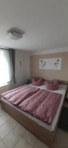 加格尔Familie Fritz的一间卧室配有一张带粉红色棉被的大床