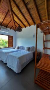 卡拉伊瓦Aldeia Biribiri - Pousada的一间卧室设有两张床和木制天花板