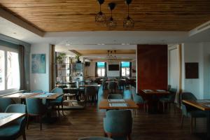 Courroux德乐奥酒店的餐厅设有木制天花板和桌椅