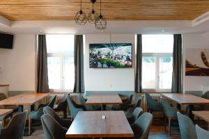 Courroux德乐奥酒店的餐厅设有木桌、椅子和窗户。