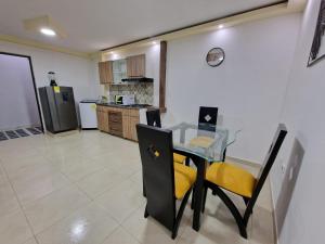 佩雷拉Las Margaritas apartments, Pereira City Centre的厨房配有玻璃桌和黄色椅子