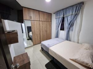 佩雷拉Las Margaritas apartments, Pereira City Centre的一间小卧室,配有一张床和镜子