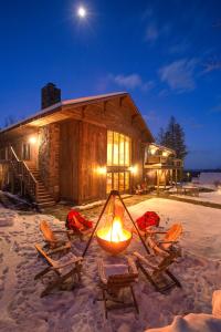泊鲁Seesaw's Lodge的小木屋,配有椅子和雪地壁炉
