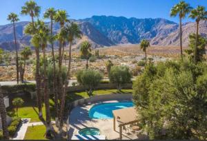 棕榈泉Palm Springs Perfect Getaway的一座棕榈树和山脉环绕的游泳池