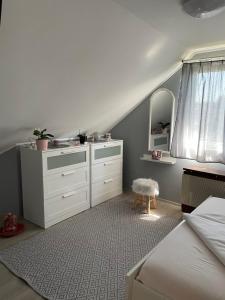 Gyöngyszem Apartman的卧室配有白色梳妆台和镜子