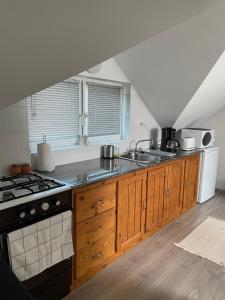 Gyöngyszem Apartman的厨房配有木制橱柜和炉灶烤箱。