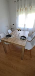 CepedaCasa La Torre的一张带白色椅子的木桌和一间餐厅