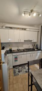 CepedaCasa La Torre的厨房配有白色橱柜、水槽和桌子
