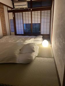 京都Kyomachiya Momo - Vacation STAY 29895v的卧室配有一张带灯光的床铺,位于地板上