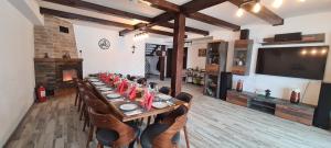 莱斯诺夫Cabana Floare de Colt 2的长长的用餐室配有长桌子和椅子
