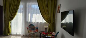 莱斯诺夫Cabana Floare de Colt 2的客房设有椅子、桌子和大窗户。