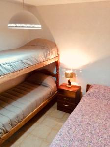 蒂尔卡拉Casa en Tilcara con hermosa vista al Pucara的一间卧室配有一张双层床和一张带台灯的桌子