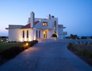 科斯基努Villa Artemis的夜间有车道的大型白色房屋