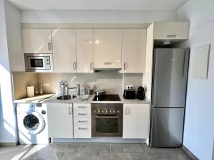 特拉萨Loft moderno en buena ubicación的厨房配有白色橱柜和不锈钢冰箱