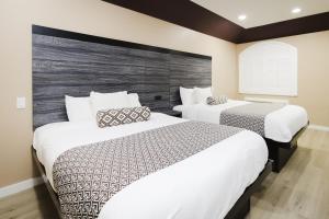 钱诺夫Sapphire Inn & Suites的白色的酒店客房内的两张床