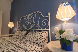 科森扎"7 SORELLE B&B" camere in pieno centro città con bagno privato, FREE HIGH SPEED WI-FI, NETFLIX的一间卧室配有一张床和一张带台灯的桌子