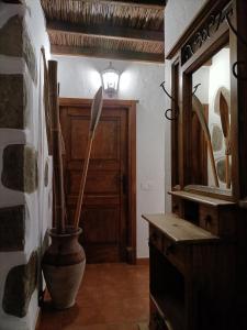圣巴托洛梅Rural Suite Santiago de Tunte的一间设有镜子和一个带扫 ⁇ 的花瓶的房间