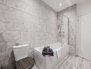 克鲁Derrington House - By Sigma Stays的白色的浴室设有浴缸、卫生间和浴缸。
