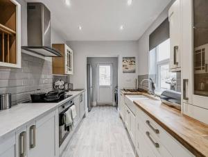 克鲁Derrington House - By Sigma Stays的一间铺有木地板的大厨房,配有白色的橱柜