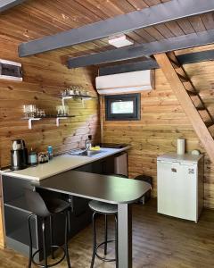 萨潘贾BLS BUNGALOVE SAPANCA的厨房设有木墙和带凳子的台面。