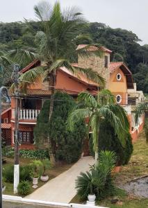 瓜鲁雅Castelinho do Felix Guarujá Pernambuco的前面有棕榈树的房子