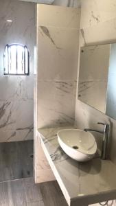 迪坡斯特兰Hostal Casa Flor de Limón的白色的浴室设有水槽和镜子