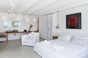 米克诺斯城She Mykonos - The Residency的白色的客厅配有白色的床和椅子