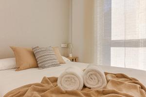 拉科鲁尼亚Riazor Deluxe Penthouse的一间卧室配有带毛巾的床