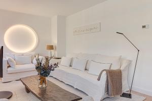 拉科鲁尼亚Riazor Deluxe Penthouse的客厅配有白色的沙发和桌子