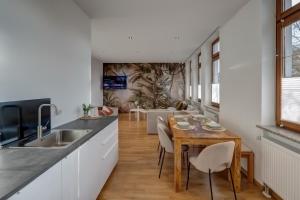 奥格斯堡Kaza Guesthouse, centrally located 2 & 3 bedroom Apartments in Augsburg的厨房以及带木桌和椅子的用餐室。