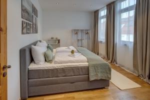 奥格斯堡Kaza Guesthouse, centrally located 2 & 3 bedroom Apartments in Augsburg的卧室配有一张带白色墙壁的大床