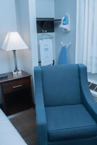 麦迪逊AmericInn by Wyndham Madison WI的一张蓝色椅子,坐在房间床边