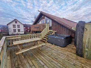 莱旺厄尔Unik fjøsleilighet的木甲板,带长凳和建筑