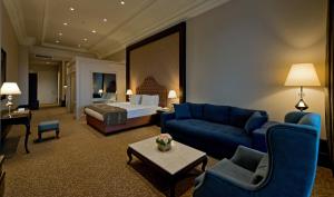 伊斯坦布尔Vialand Palace Hotel的客厅配有蓝色的沙发和床。
