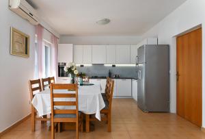 特罗吉尔Holiday house Vukman的厨房配有桌椅和冰箱。