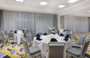 新奥尔良新奥尔良东温德姆花园酒店的一间会议室,配有白色的桌椅